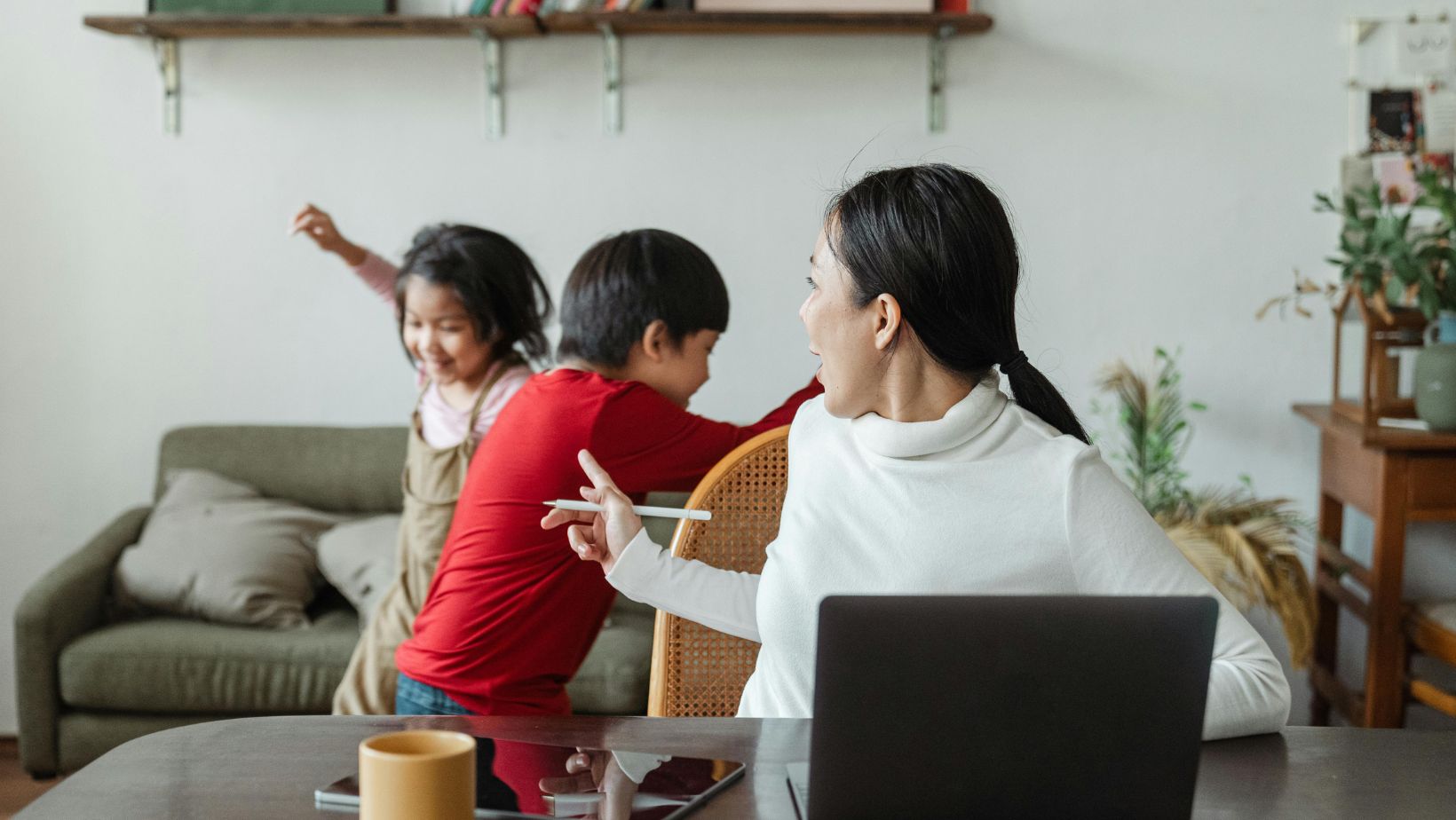 Woman shushing her children as she works.
