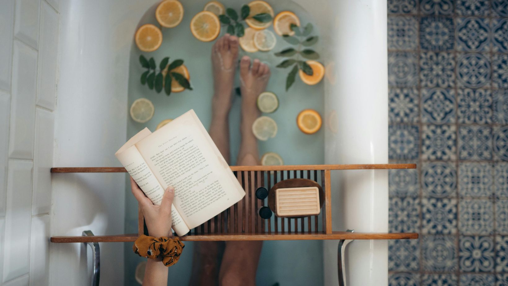 Woman reading a book in a bathtub.